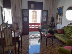 un soggiorno con divani verdi e un tavolo di Stardust House Vegueta a Las Palmas de Gran Canaria