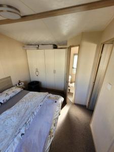 um quarto com uma cama grande num quarto em K & K Caravan Southview em Skegness