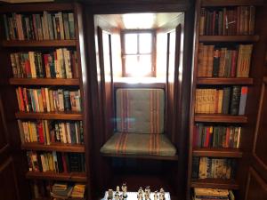 una habitación con una silla en una biblioteca con libros en Lickleyhead Castle en Insch