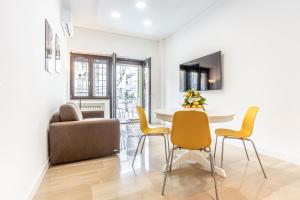 salon ze stołem, krzesłami i kanapą w obiekcie Vomero Deluxe Apartments w mieście Neapol