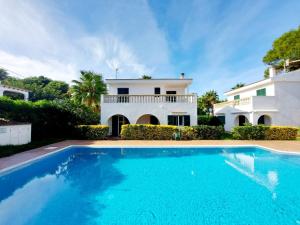 a villa with a swimming pool in front of a house at Villa Limón in Cala Blanca