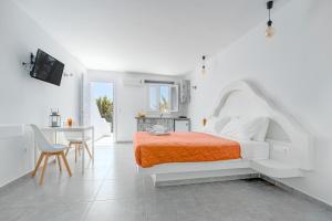a white bedroom with a bed and a table at IL Vento Suites in Mikonos