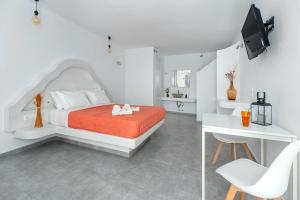 a white bedroom with a bed and a desk at IL Vento Suites in Mikonos +64 photos