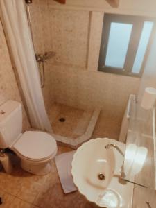 a bathroom with a toilet and a sink and a shower at Kristi's Homes - "Beautiful Attic" in Dimitsana in Dhimitsana