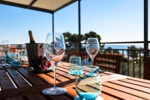 a wooden table with wine glasses and a plate of fruit at Timm apartment in Vir