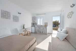 a white room with a bed and a couch at IL Vento Suites in Mikonos