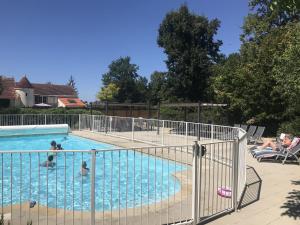 a swimming pool with people in the water at Les Vieilles Ombres in Bagnizeau +55 photos