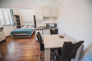 a kitchen and dining room with a table and a bed at Studio CENTER in Zgornje Jezersko