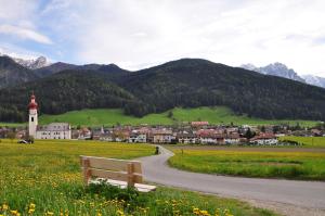 a bench sitting in a field next to a road at Aurturist Villabassa in Villabassa
