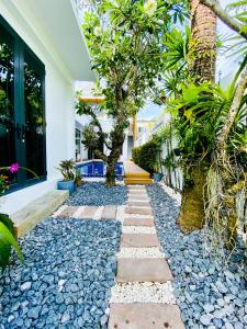 un giardino con rocce e alberi e una casa di Villa Soi Mangosteen a Rawai Beach
