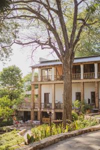 a large house with a tree in front of it at Casa Del Val - Villa María Hotel in San Bernardino