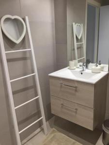 ein Badezimmer mit einer Leiter neben einem Waschbecken und einem Spiegel in der Unterkunft Bienvenue A La Campagne in Villers-sur-Port