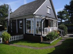 a small black house with a porch and windows at Ferienwohnung Ambiente in Bedekaspel