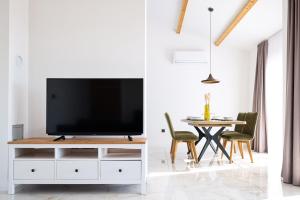 a living room with a tv on a white cabinet at Timm apartment in Vir