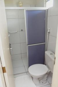 a small bathroom with a toilet and a shower at Pousada Do Inglês in Jacumã