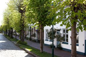 a row of trees in front of a white building at SCHLEI LIEBE in Arnis