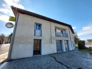 a white building with two windows and a door at L'Accent - Groupe Logis Hotels in Astaffort