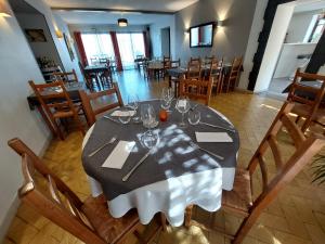 een eetkamer met een tafel met wijnglazen erop bij L'Accent - Groupe Logis Hotels in Astaffort