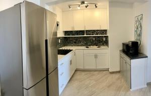 a kitchen with white cabinets and a stainless steel refrigerator at Sapphire Beach Villa Ocean and Marina View in Nazareth