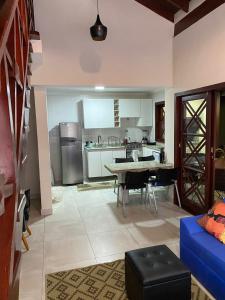 a large kitchen with a table and a blue couch at Apartamento com varanda em frente a Praia de Maresias in São Sebastião