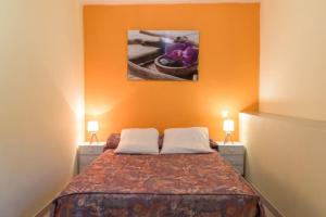 a bedroom with a bed with an orange wall at Appartement dans maison chaleureuse in Olmeto