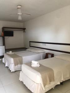 Habitación con 2 camas y toallas. en Mar & Sol Praia Hotel, en Prado