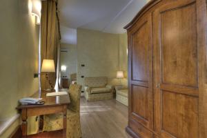 a room with a desk and a large wooden cabinet at Central Park Hotel Modena in Modena