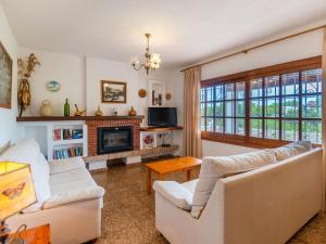 sala de estar con 2 sofás blancos y chimenea en Holiday Home Can Pep Jaume by Interhome, en Es Canar