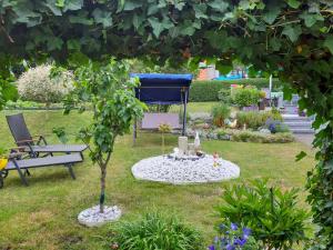 een tuin met een bank en een boom in het gras bij Holiday Home Schneider by Interhome in Geschwenda +12 foto's