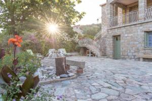 a stone patio with a bench and a building at Appartement dans maison chaleureuse in Olmeto