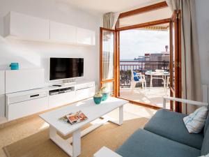 Una sala de estar con un televisor, un sofá y una mesa. en Apartment Cofisa-2 by Interhome, en Jávea