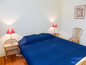 a bedroom with a blue bed and two chairs at Holiday Home Dominique by Interhome in Lacanau-Océan