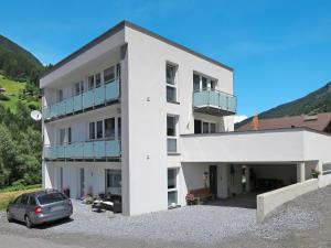 un edificio bianco con un'auto parcheggiata di fronte di Apartment Tschiderer by Interhome a See
