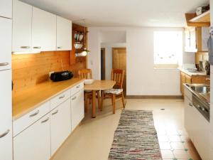 ザンクト・ガレンキルヒにあるHoliday Home Fitsch - GOP320 by Interhomeの白いキャビネットと木製テーブル付きのキッチン
