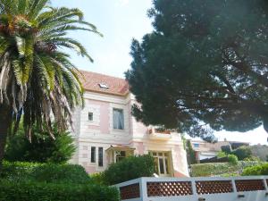 a pink house with a palm tree in front of it at Apartment Castel Haussmann-1 by Interhome in Cavalaire-sur-Mer +15 photos