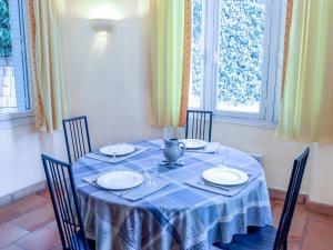 a dining room table with a blue table cloth and chairs at Apartment Castel Haussmann-1 by Interhome in Cavalaire-sur-Mer
