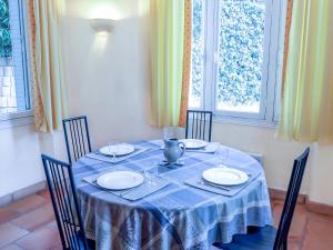 una mesa de comedor con un paño de mesa azul y sillas en Apartment Castel Haussmann-1 by Interhome en Cavalaire-sur-Mer