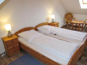 a bedroom with two beds and a table and chairs at Holiday Home Katamaran I by Interhome in Burhave
