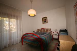 马里纳-迪卡斯塔涅托Appartamento indipendente con Giardino ideale per famiglie的卧室里有一张床、一张桌子和一盏灯