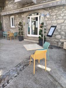 une table et des chaises devant un bâtiment dans l'établissement Auberge du Vieux Lanas Logis Hotel Restaurant, à Lanas