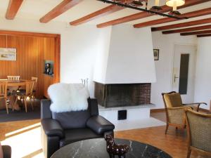 a living room with a chair and a fireplace at Apartment Chalet Shangri La by Interhome in Grindelwald