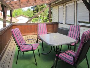 a patio with a table and chairs on a porch at Holiday Home Aurora by Interhome in Kurort Steinbach-Hallenberg