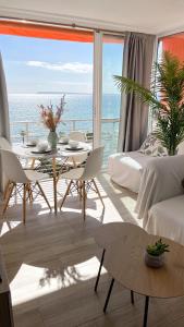 un soggiorno con tavolo e vista sull'oceano di Apartamento en 1ª línea con piscina ad Alicante