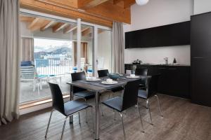 een keuken en eetkamer met een tafel en stoelen bij Townhouse N26 in St. Moritz