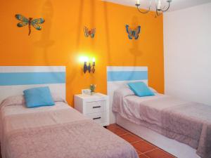 フリヒリアナにあるHoliday Home La Era - FRG130 by Interhomeの蝶が壁に描かれた部屋のベッド2台