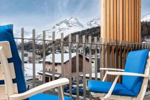 a balcony with chairs and a view of mountains at Townhouse N26 in St. Moritz