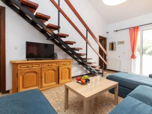 un salon avec un canapé bleu et une télévision dans l'établissement Holiday Home Pfeil - TDM170 by Interhome, à Torroella de Montgrí