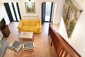 ein Wohnzimmer mit einem gelben Sofa und Stühlen in der Unterkunft Locazione Turistica Arcobaleno "Family Loft" in Roccavivara