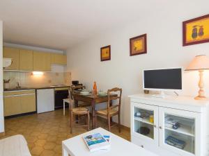 a living room with a kitchen and a table with a television at Apartment La Croix du Sud-3 by Interhome in Cavalaire-sur-Mer