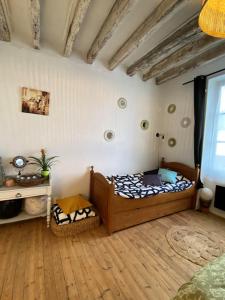 - une chambre avec un lit en bois dans l'établissement Les petites Mirabelles, à Noyers-sur-Cher